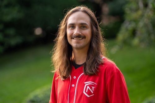 Picture of Adam Smith, a smiling man with long brown hair and mustache
